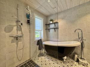 a bathroom with a large tub and a shower at Bjørnebo, Family cabin in Torpo +32 photos