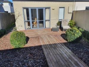 Un patio trasero con una terraza de madera y una silla. en 3-Bedrooms Home near CBD, en Christchurch 13 fotos más