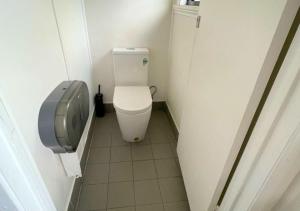 a small bathroom with a toilet and a urinal at The Grand Hotel Cairns in Cairns +8 photos