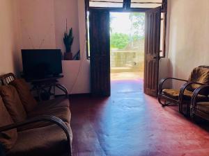a living room with a couch and a television at Ku'Vana Hostel Kandy in Kandy