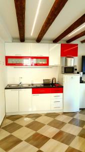 a kitchen with white appliances and red cabinets at Karmen's Apartment One in Split