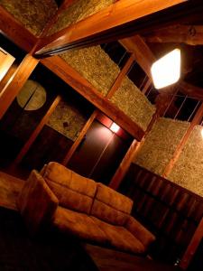 a brown couch sitting in the middle of a room at 民泊やがみ-Yagami- in Sanagu