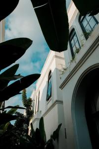 un edificio blanco con ventanas y plantas. en Greenforest Anahata 5 Star Villa Hotel, en Canggu