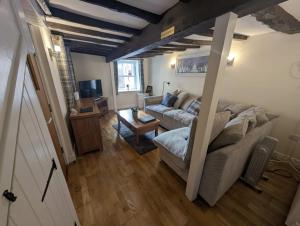 een woonkamer met een bank en een tafel bij Hocking Cottage in Torquay