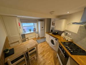 een keuken met een wasmachine en droger in de kamer bij Hocking Cottage in Torquay