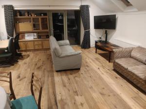 ein Wohnzimmer mit Sofa und Fernseher in der Unterkunft Upper Barn at the Flax Mill in Coleraine