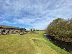 ein altes Steingebäude neben einem Fluss in der Unterkunft Upper Barn at the Flax Mill in Coleraine