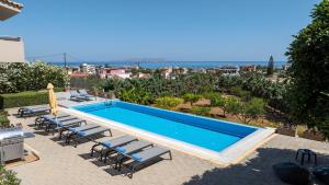 - une piscine avec des chaises longues dans l'établissement Four Seasons private villa - seaview - big heated pool - gym - sport activities, à Gouves