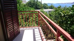 a balcony with a wooden railing and a view of the ocean at Apartments Petković in Kučište