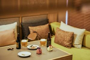 a table with two bottles of beer and a plate of food at OMO5 Kyoto Gion by Hoshino Resorts in Kyoto