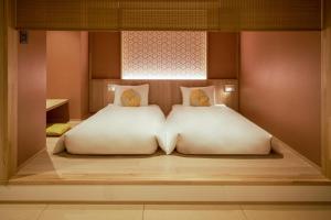 a bed in a room with two white pillows at OMO5 Kyoto Gion by Hoshino Resorts in Kyoto