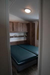a small room with a bed in a room at Chalet - Camping Natuurlijk Limburg in Remersdaal