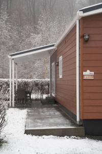 a covered porch of a house in the snow at Chalet - Camping Natuurlijk Limburg in Remersdaal