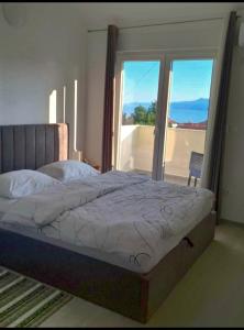 a bedroom with a bed with a view of a balcony at Apartment Tanya in Rijeka +62 photos