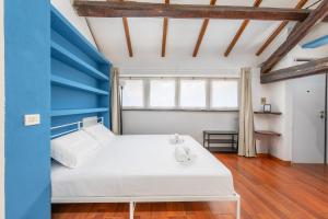 a bedroom with a white bed and a blue wall at Easy Parking - 1 min from Bus to San Siro Stadium - Air Conditioning in Milan