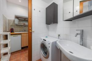 a bathroom with a washing machine and a sink at Easy Parking - 1 min from Bus to San Siro Stadium - Air Conditioning in Milan