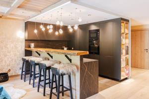 Rochebrune - Appartement de luxe في ميجيف: مطبخ مع بار مع الكراسي حوله