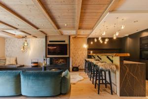 Rochebrune - Appartement de luxe في ميجيف: غرفة معيشة مع بار مع كراسي