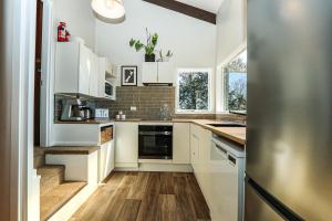 cocina con armarios blancos y suelo de madera en Lake Escape-stunning views and close to town, en Lake Tekapo