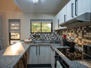 a kitchen with a sink and a counter top at Kumusha Cottages in Kasane +8 photos