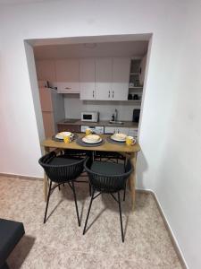 a small kitchen with a table with two chairs at Alma azul in Puerto de Mazarrón