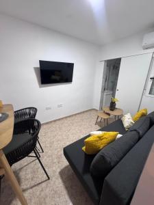 a living room with a black couch and a table at Alma azul in Puerto de Mazarrón
