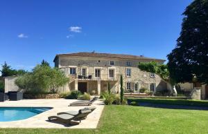 a large house with a swimming pool in front of it at Domaine Chamarel in Saint-Paulet-de-Caisson