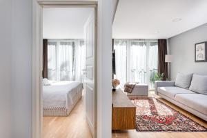 a bedroom with a bed and a living room with a couch at Central Square Apartments in Palanga