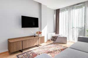 a living room with a flat screen tv on a wall at Central Square Apartments in Palanga