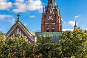 a church with a clock tower on top of it at Central Square Apartments in Palanga
