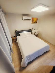 ein Schlafzimmer mit einem großen weißen Bett und einem Schreibtisch in der Unterkunft DDP Families & Friends House in Seoul + 15 Fotos