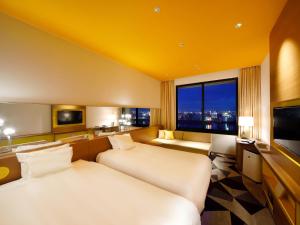 a hotel room with two beds and a large window at Hotel Universal Port Vita in Osaka