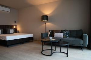 a living room with a bed and a couch and a table at Camping Natuurlijk Limburg - Studio in Remersdaal