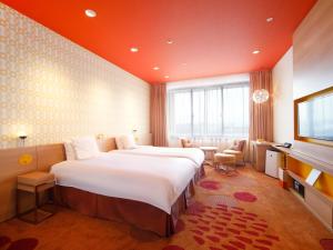 a hotel room with a large bed and a television at Hotel Universal Port Vita in Osaka
