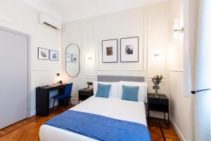 a white bedroom with a bed and a desk at Piazza del Popolo Boutique GuestHouse in Rome