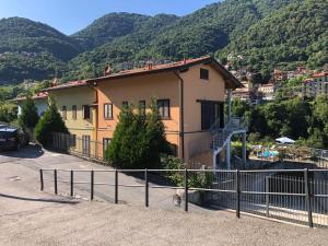 a house with a fence in front of a mountain at Residence Borgo Castello E1 Apartment in Argegno