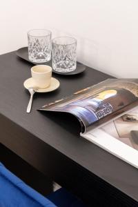 a black table with two glasses and a magazine at Piazza del Popolo Boutique GuestHouse in Rome