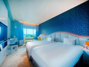a bedroom with a large bed and a blue wall at Hotel Universal Port Vita in Osaka +51 photos