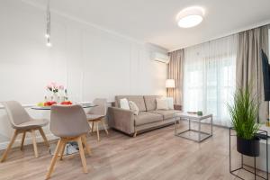 ein Wohnzimmer mit Sofa und Tisch in der Unterkunft Golden Apartments - Luxury Stay for up to 20 Guests in Mennica Residence, Warsaw Center in Warschau