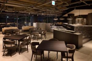 um restaurante com mesas, cadeiras e um bar em ONCRI-Karatsu おんくり唐津 em Karatsu