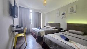 a hotel room with two beds and a television at Parkland Hotel in Brinchang +20 photos