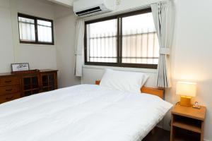 a bedroom with a large white bed and a window at 三十三Inari in Kyoto