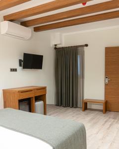 een slaapkamer met een bed, een bureau en een televisie bij Edra House in Alacati +15 foto's