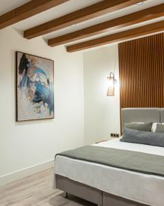 een slaapkamer met een bed en een schilderij aan de muur bij Edra House in Alacati