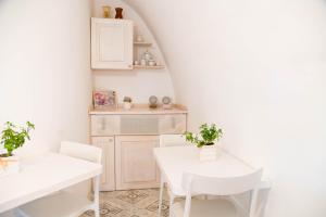 a white dining room with a white table and chairs at Terrazza Sui Trulli in Alberobello