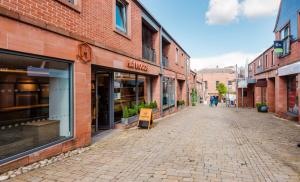 an empty street in an old brick building at First Floor Central Knutsford Apartment in Knutsford