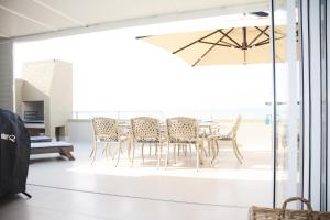a dining room with a table and chairs at Frinton on Sea4 in Ballito