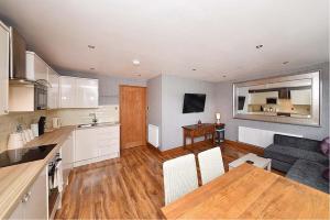 a kitchen and living room with a couch and a table at First Floor Central Knutsford Apartment in Knutsford