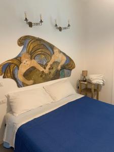 a bedroom with a painting above a bed at La Stella Marinella in Santa Marinella