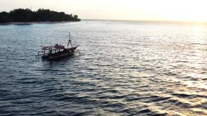ein Boot in der Mitte eines großen Wasserkörpers in der Unterkunft Cocana Resort Gili Trawangan in Gili Trawangan